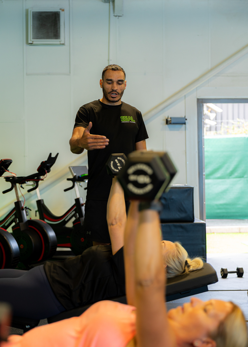 Coach guiding a Small Group chest press exercise