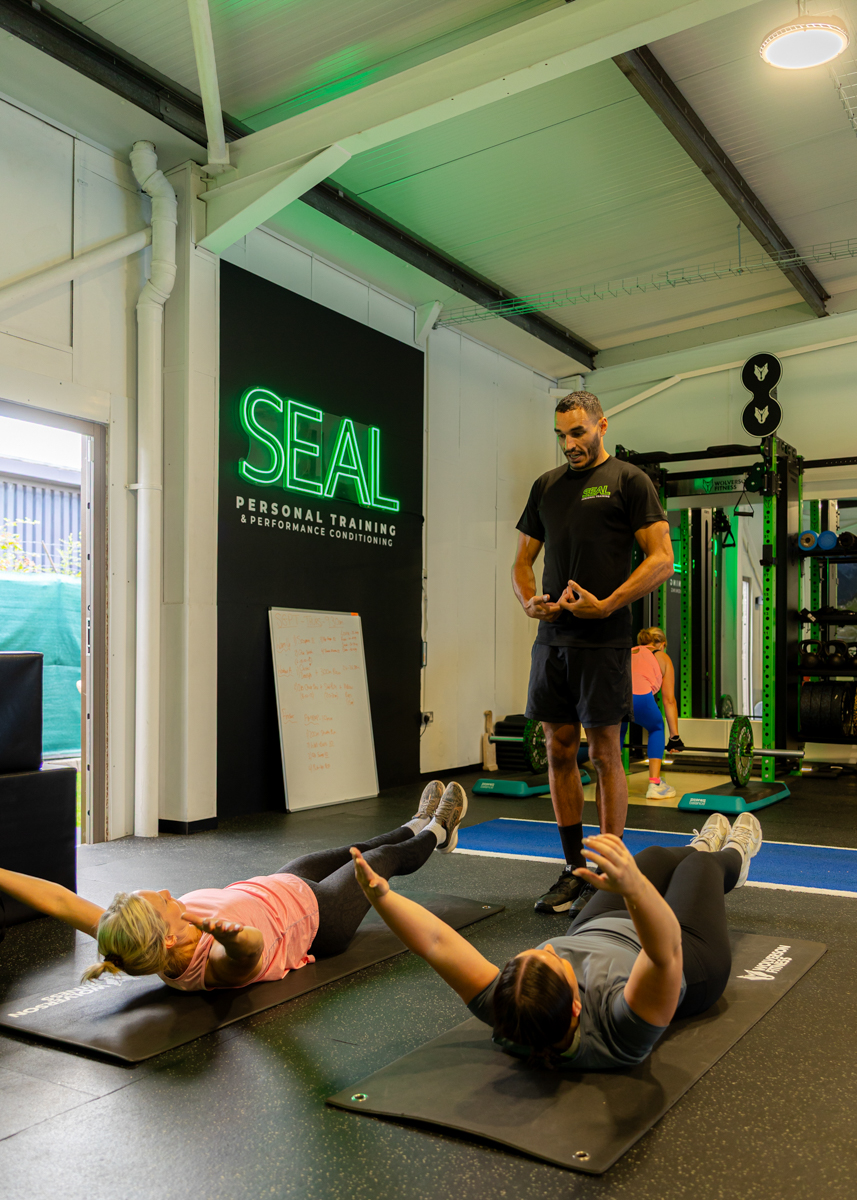 Coach leading core training on mats at SEAL Personal Training gym