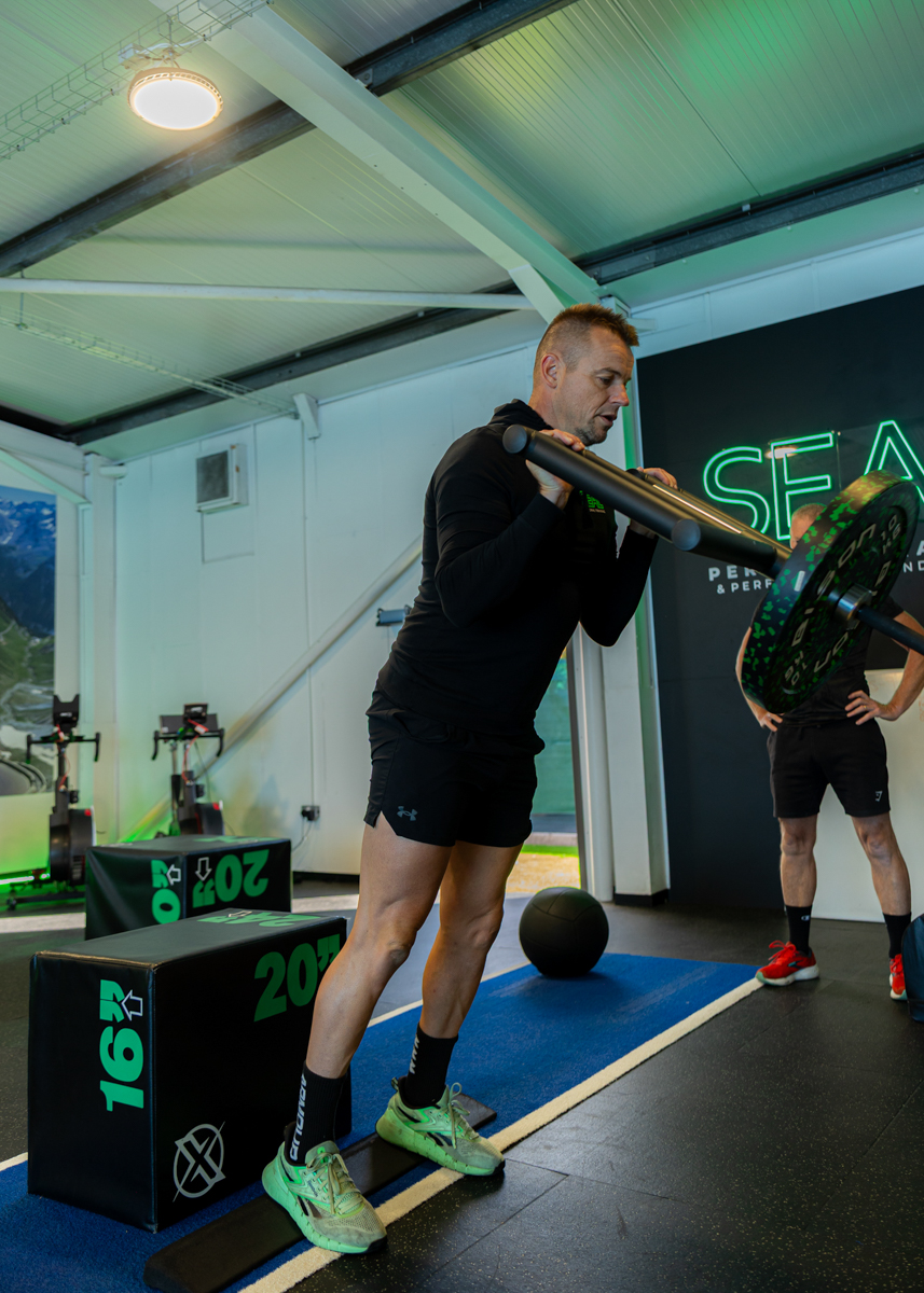 Loaded carry and step-up conditioning drill at the gym